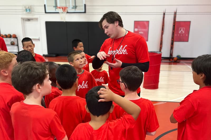 A HoopLife coach surrounded by young players listening in Regina