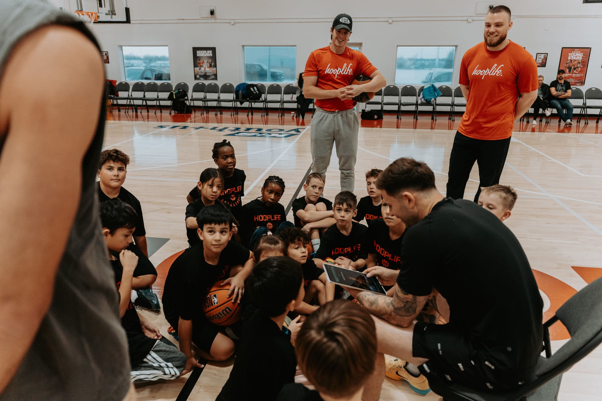 A HoopLife coach talking a whole group of players through a game plan in Regina