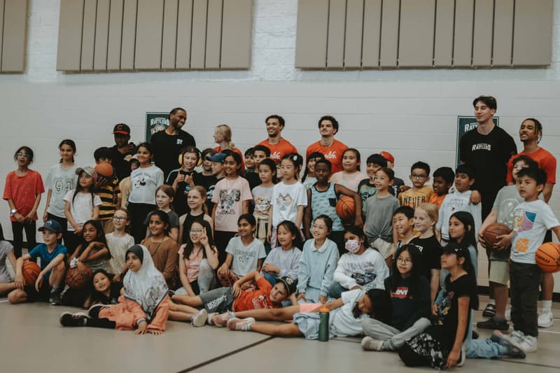 A large group of kids and HoopLife coaches together at a travel clinic gym