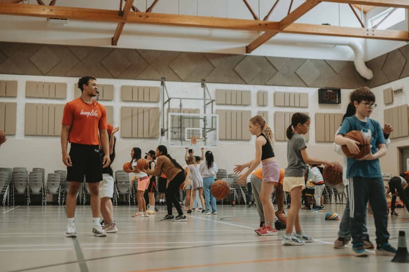 A HoopLife travel clinic underway in a community gym with players spread across the floor