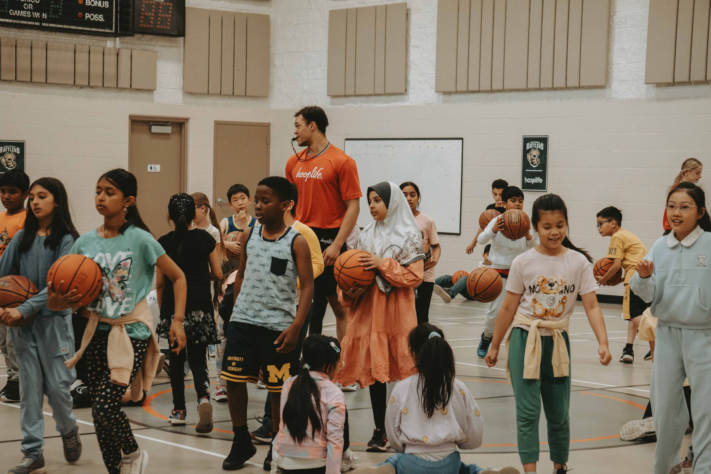 Young people with basketballs at the start of a HoopLife community clinic