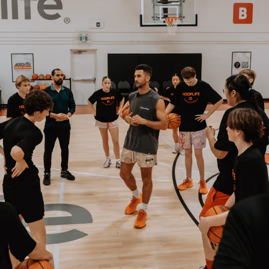 NBA skills trainer Jordan Lawley coaching a group of HoopLife players on the court in Regina