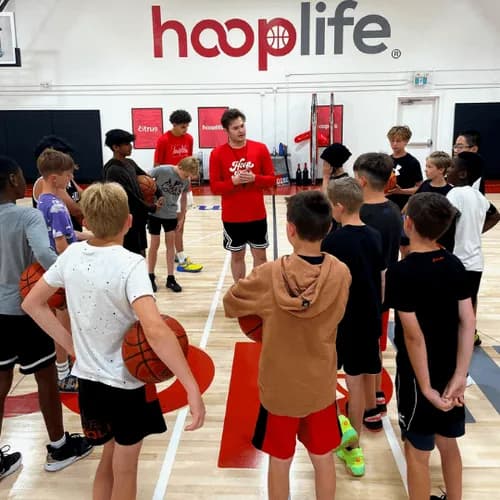 HoopLife players huddled together with a coach