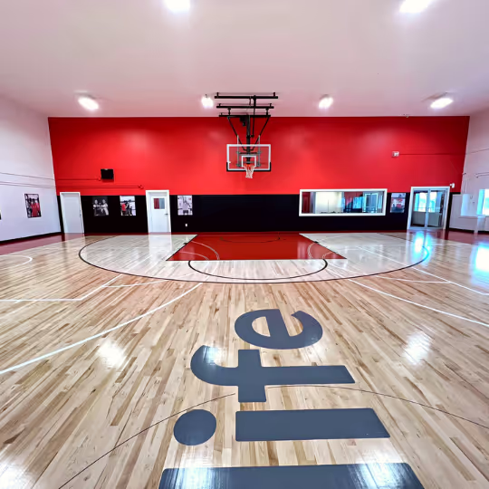 The HoopLife court from the baseline, looking at the red feature wall