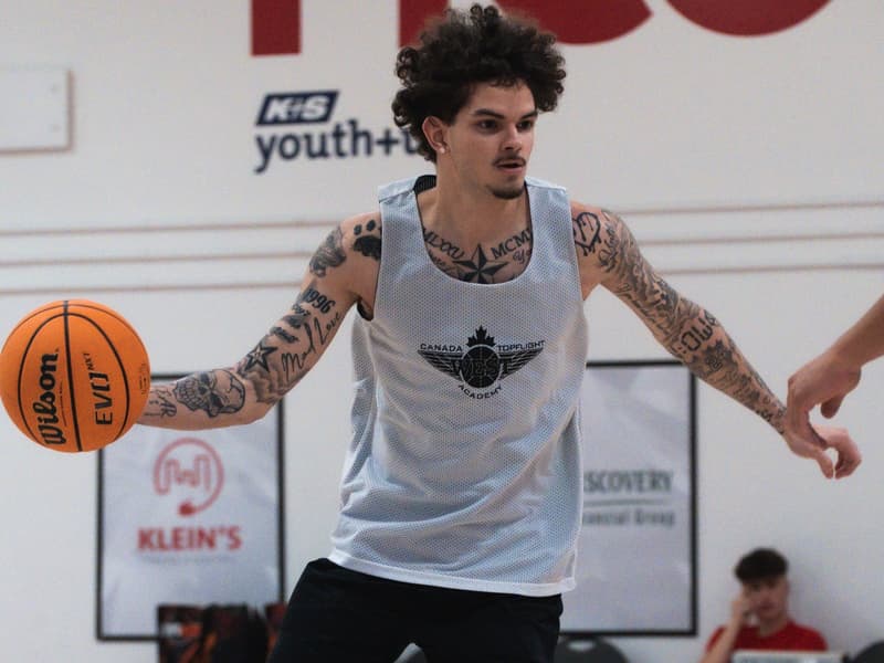 An adult league player dribbling up the floor