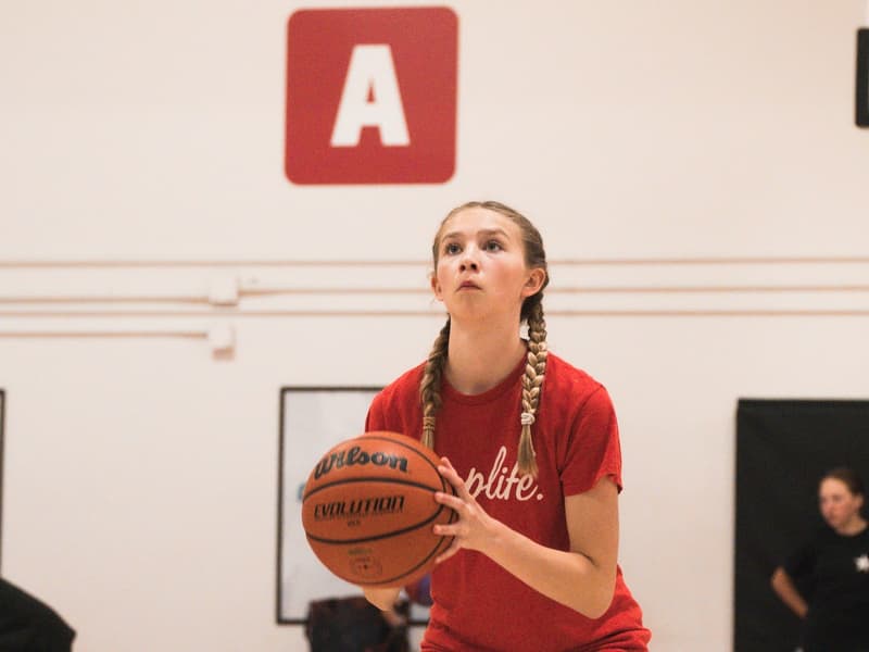 A camper lining up a shot on court A at the HoopLife Centre