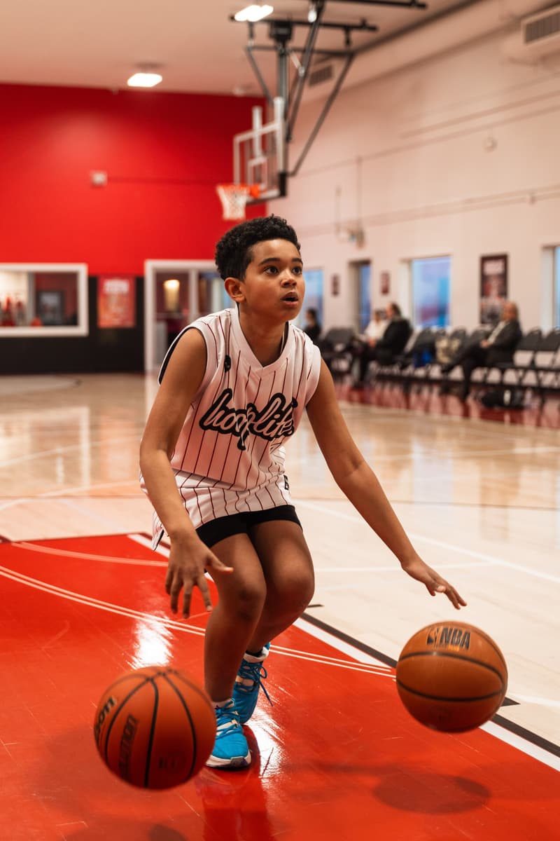 A camper controlling two basketballs in a dribbling drill