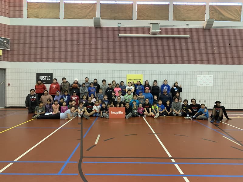 The full Kinistin camp, dozens of kids and coaches around the hooplife sign
