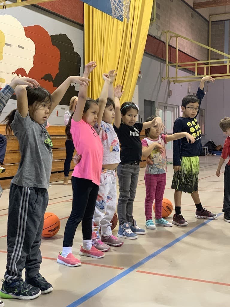 A young player holding her follow-through at the Standing Buffalo clinic
