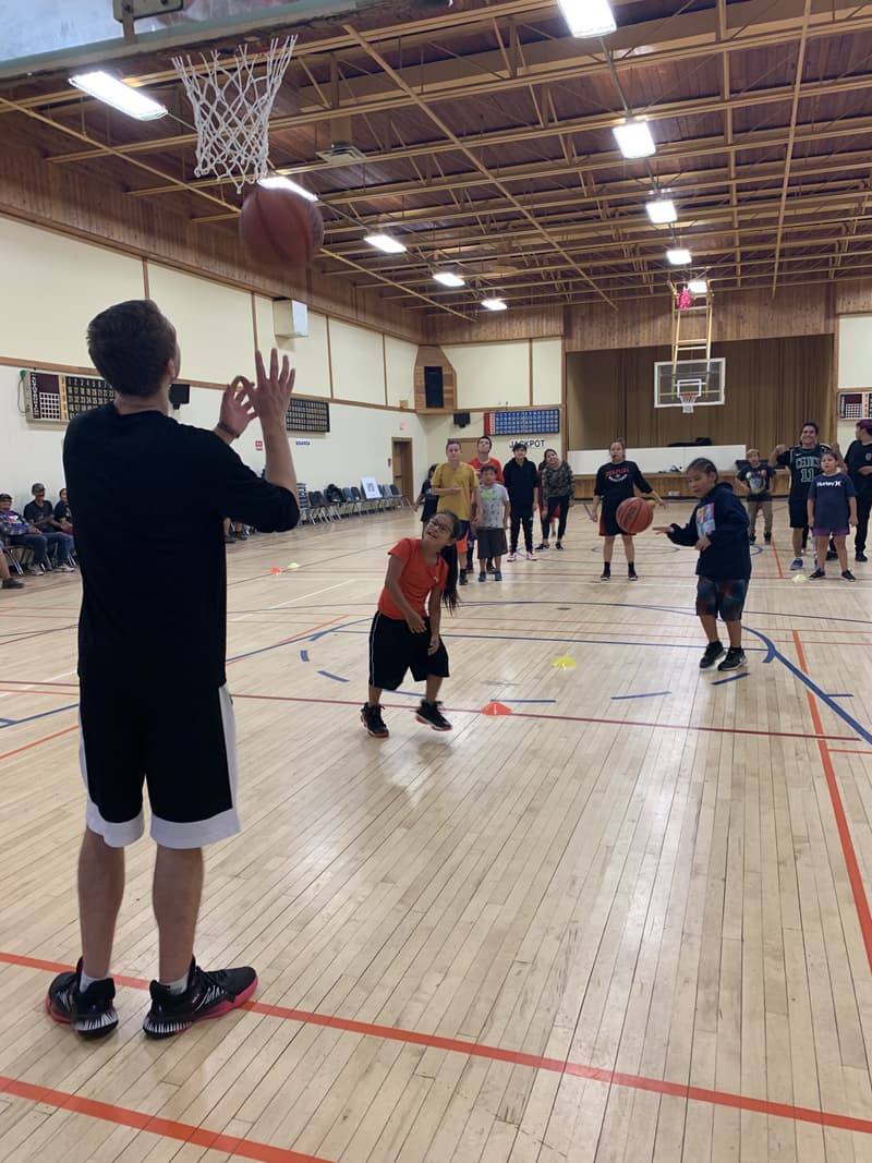A HoopLife coach rebounding under the rim during a Star Blanket shooting drill