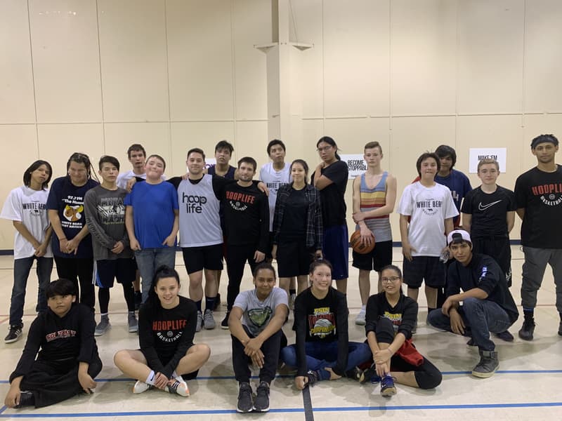 A teen group with the HoopLife coaching crew after a clinic
