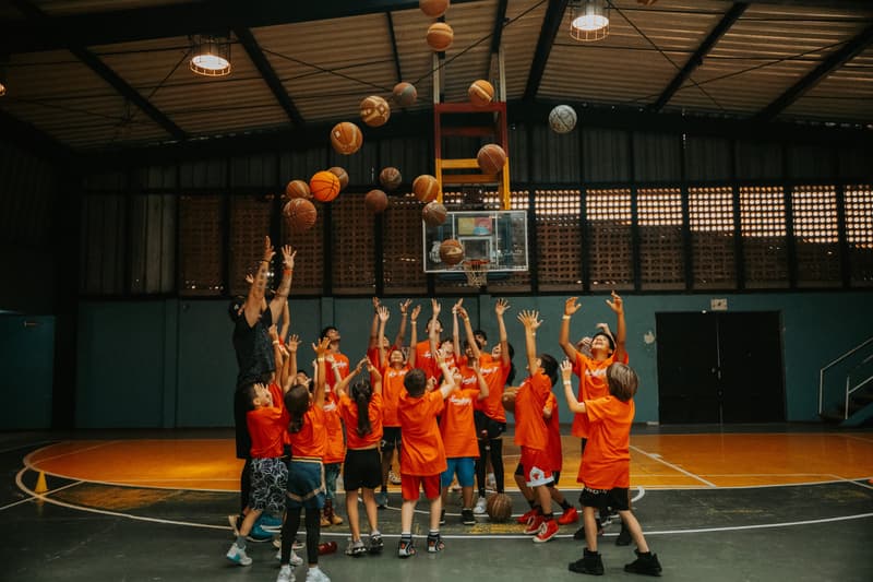 Young players throwing their basketballs in the air at the Costa Rica clinic