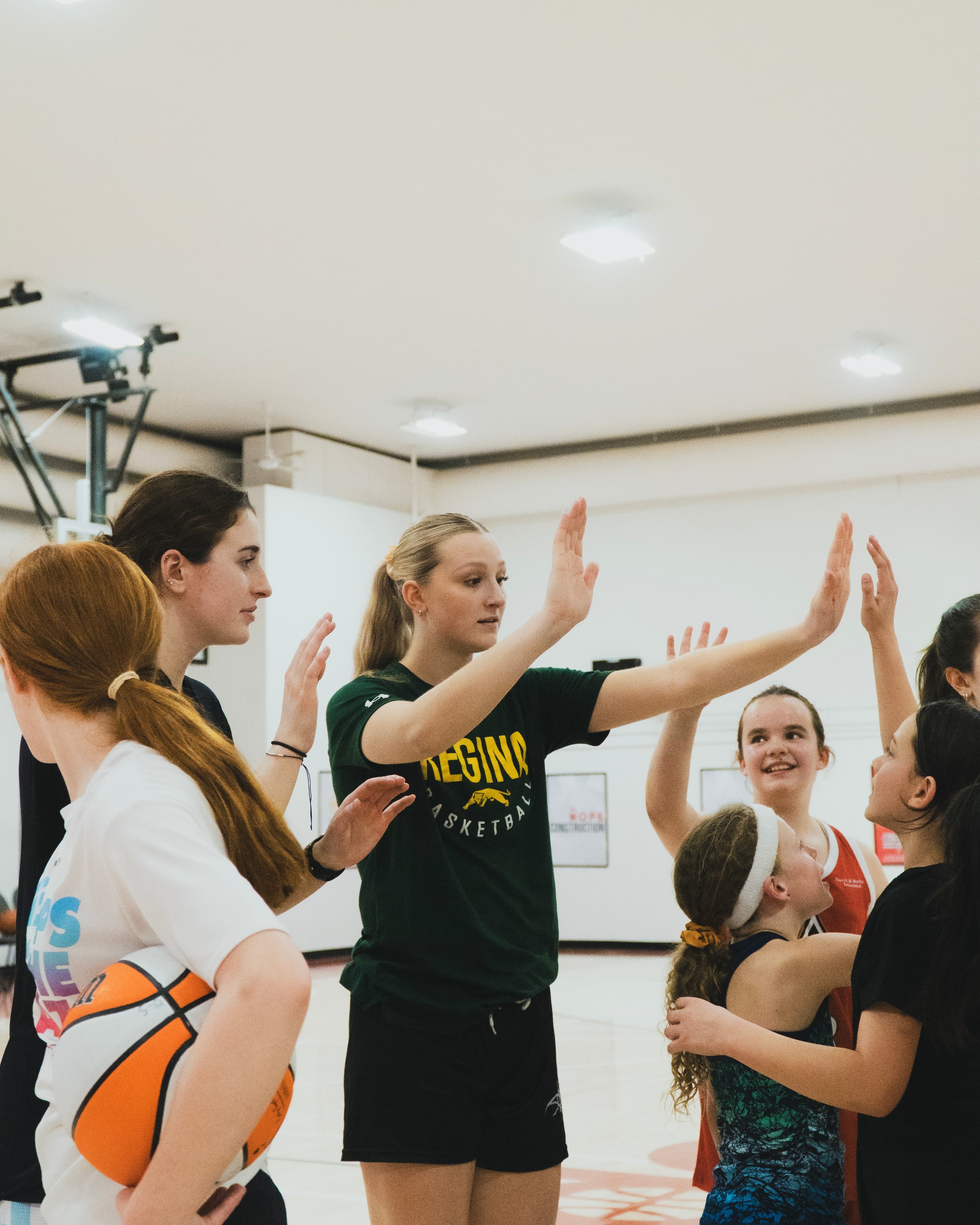 A HoopLife coach high-fiving girls at a Girls Only session