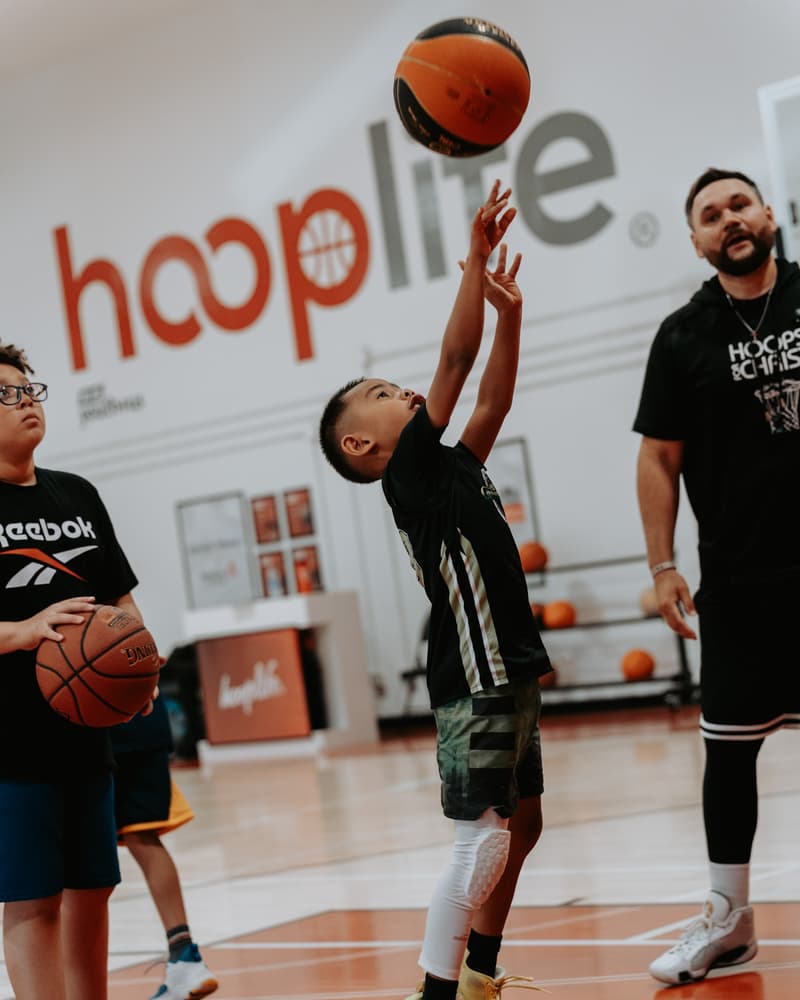 Phillip Morrison watching a young player release a shot at the hoop