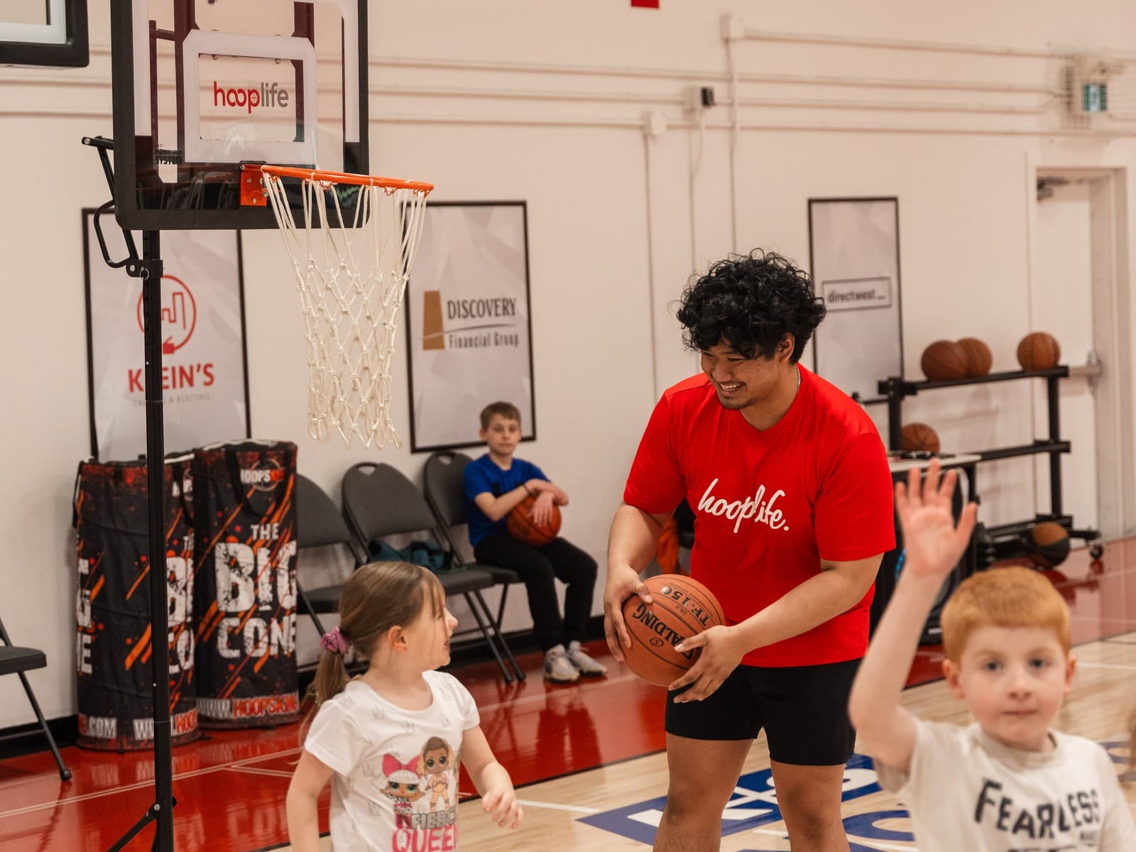 A HoopLife coach running a Young Stars class at the lowered hoop