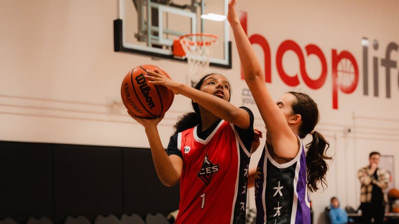 A HoopLife League player going up for a layup under the HoopLife wordmark