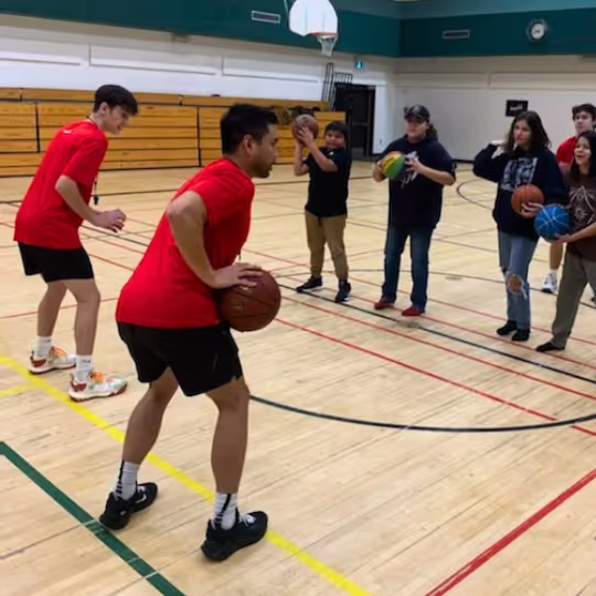 A HoopLife coach running a dribbling drill at a community clinic