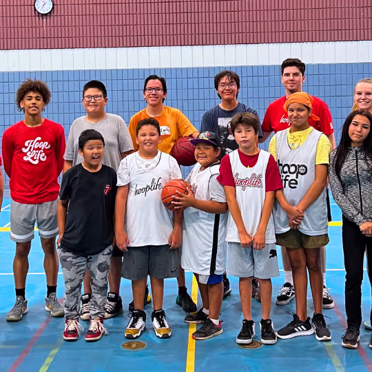 A lineup of young players and HoopLife coaches at a community gym
