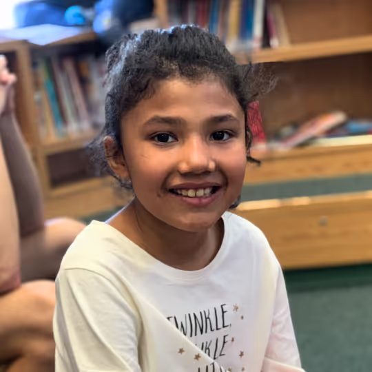 A young player smiling during the classroom part of a clinic