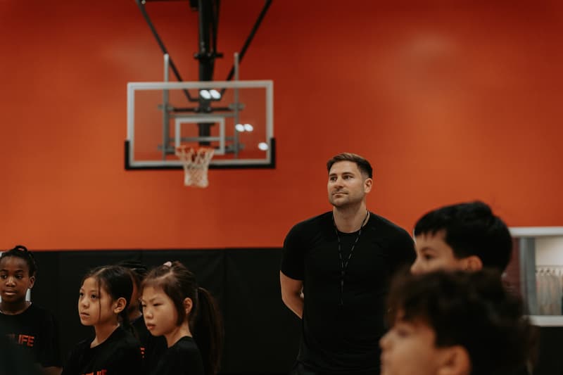 HoopLife coaches with a group of campers on the court