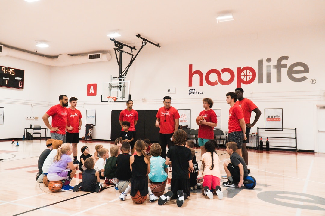 The HoopLife coaching staff with a full Young Stars group sitting on the court in Regina