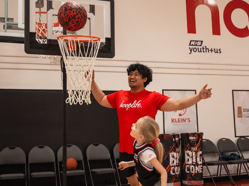 A coach with arms up celebrating a Young Stars player